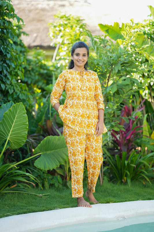 Yellow printed cotton peplum night suit with straight pants showing a functional side pocket.