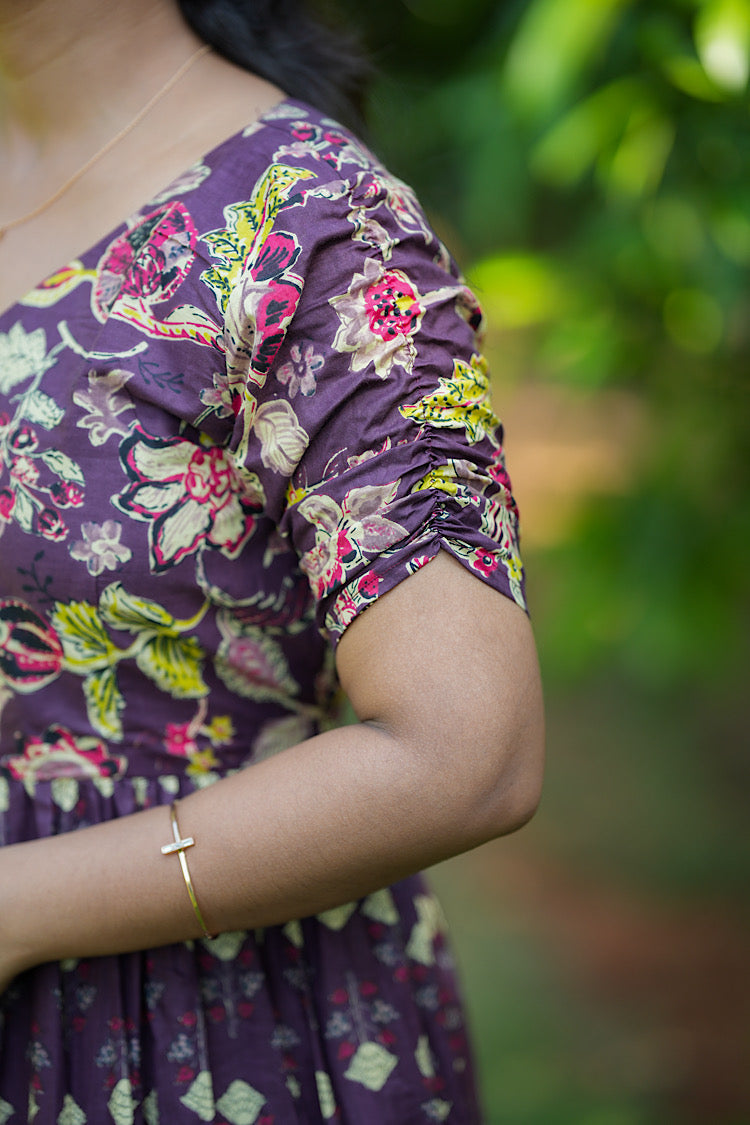Close-up of the gathered short sleeve detail on the violet printed dress