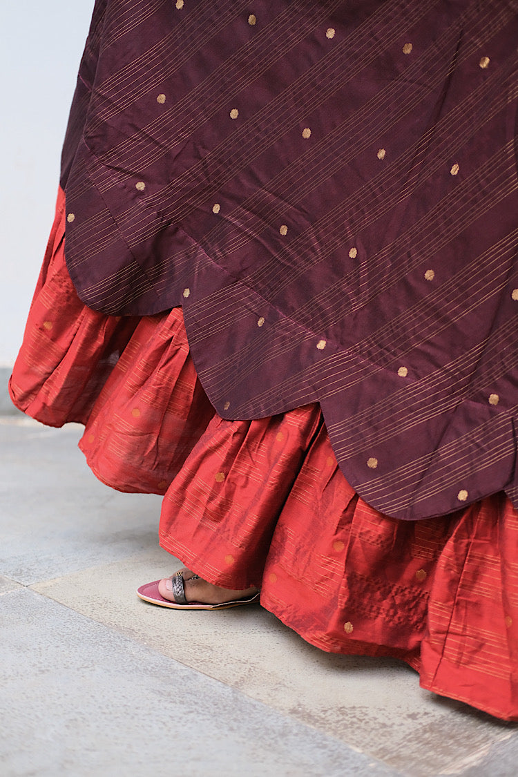 Detailed view of the scalloped border and gathered rust orange bottom tier of the ethnic maxi dress.