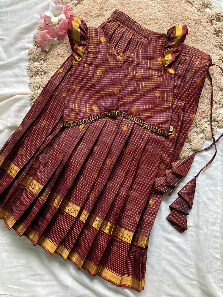 Flat lay of coffee brown checks crop top and pleated skirt set with beaded trim, ruffled sleeves, and tiered fabric tassels