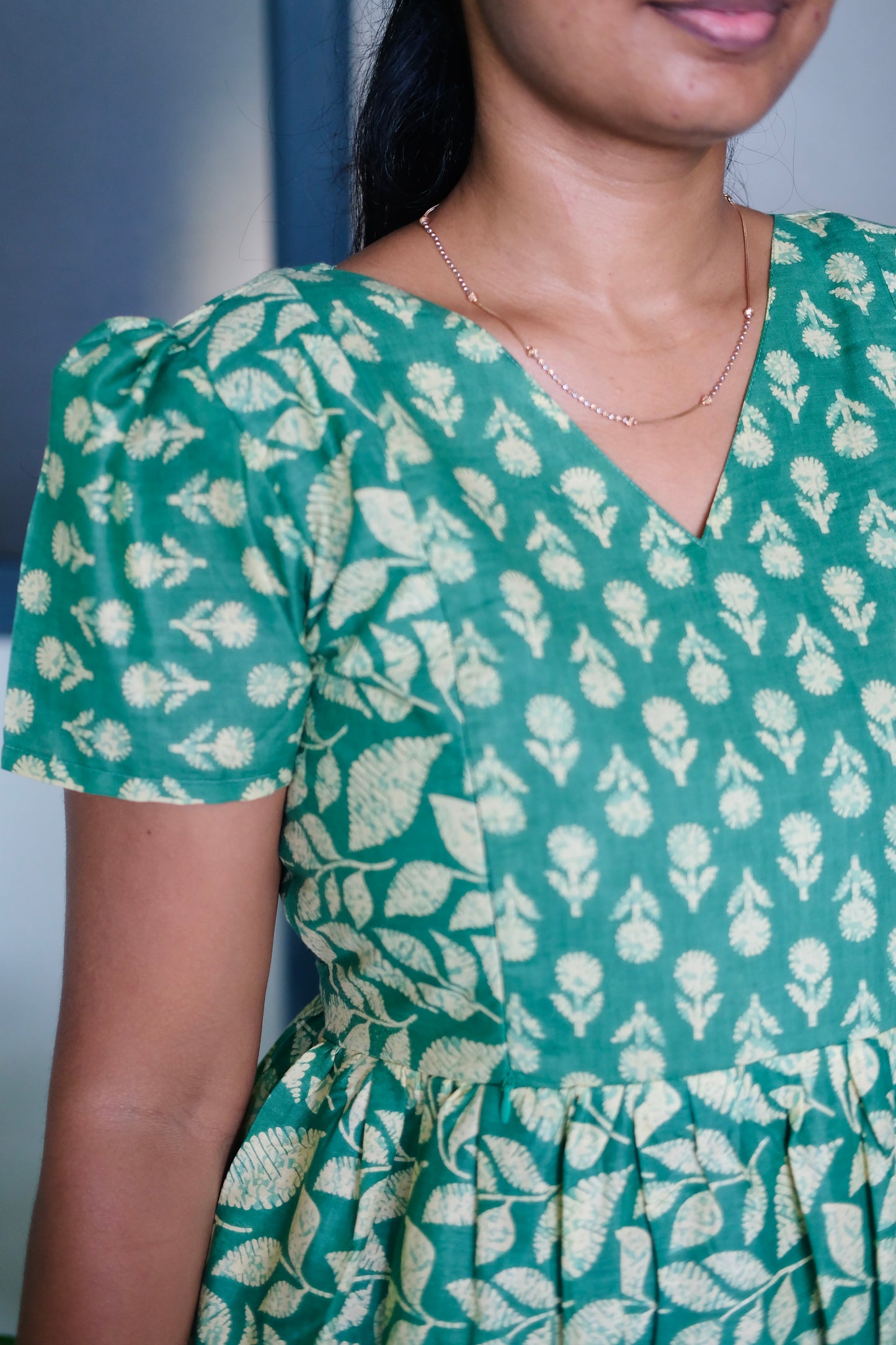 Close-up of the V-neckline and puff sleeve detail on the green feeding nighty with zip