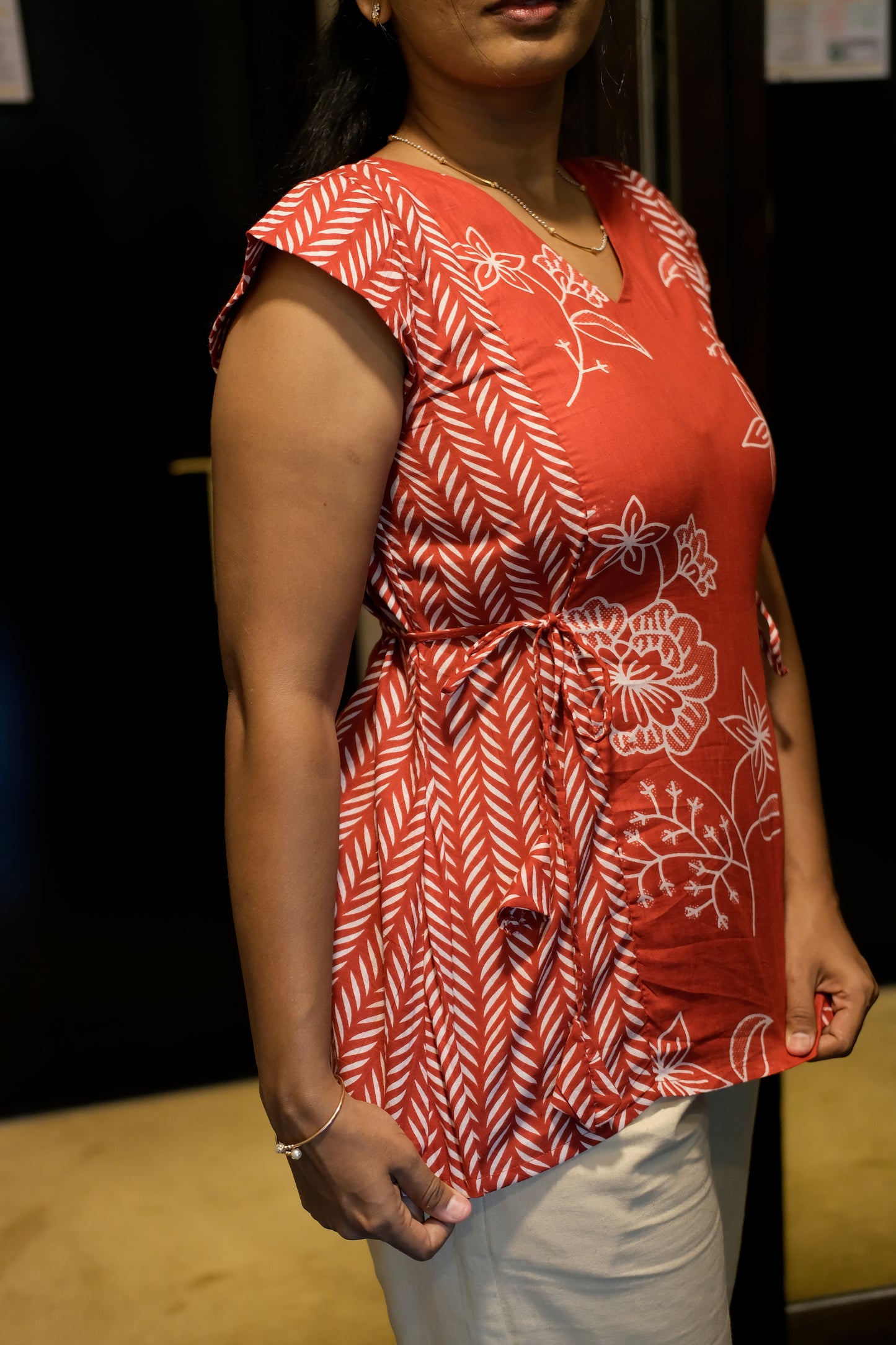 Close-up of the red printed cotton top showing the dual white print and adjustable tie-up detail.