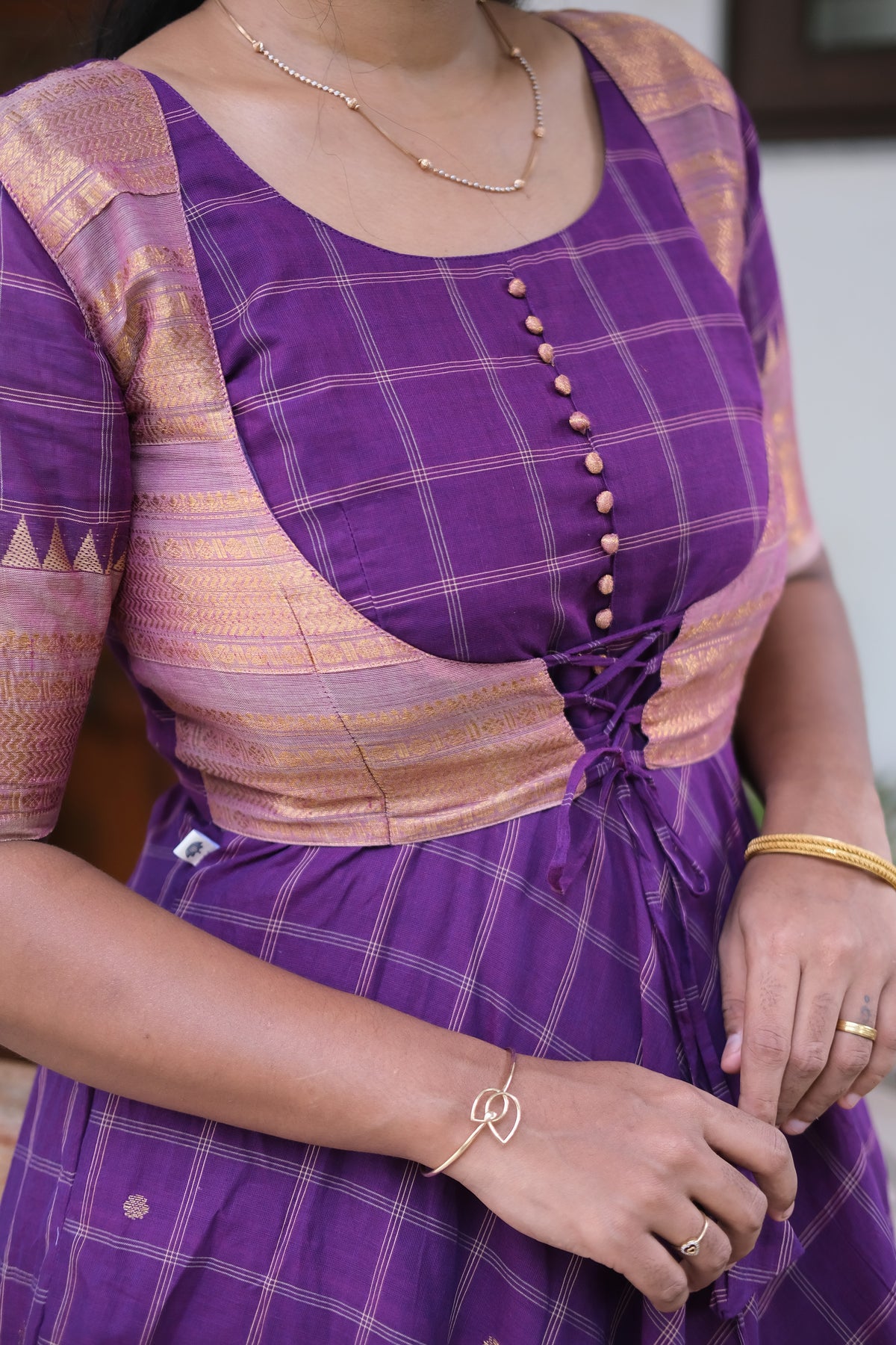 Close-up of the lace-up corset overcoat on the violet cotton maxi dress