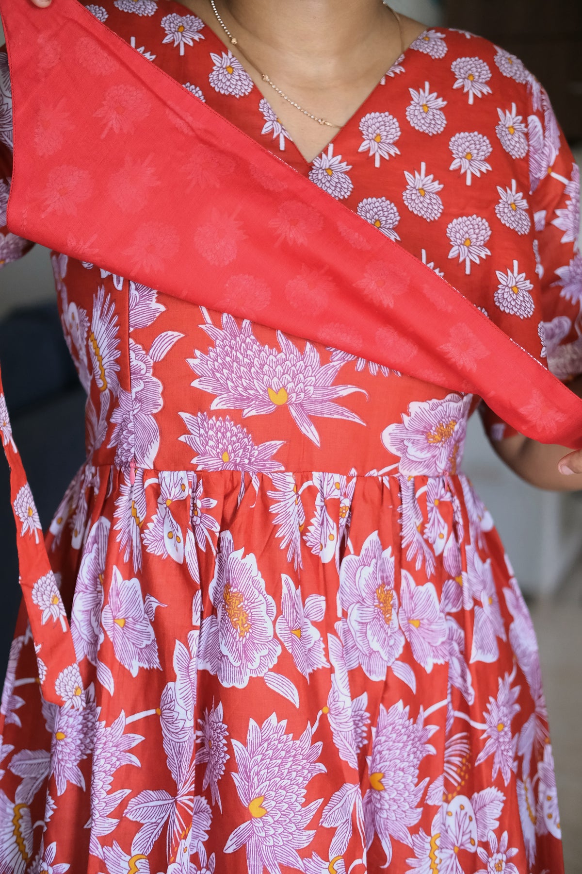 Close-up of red cotton feeding nighty showing overlapping tie-up cover panel and hidden zip