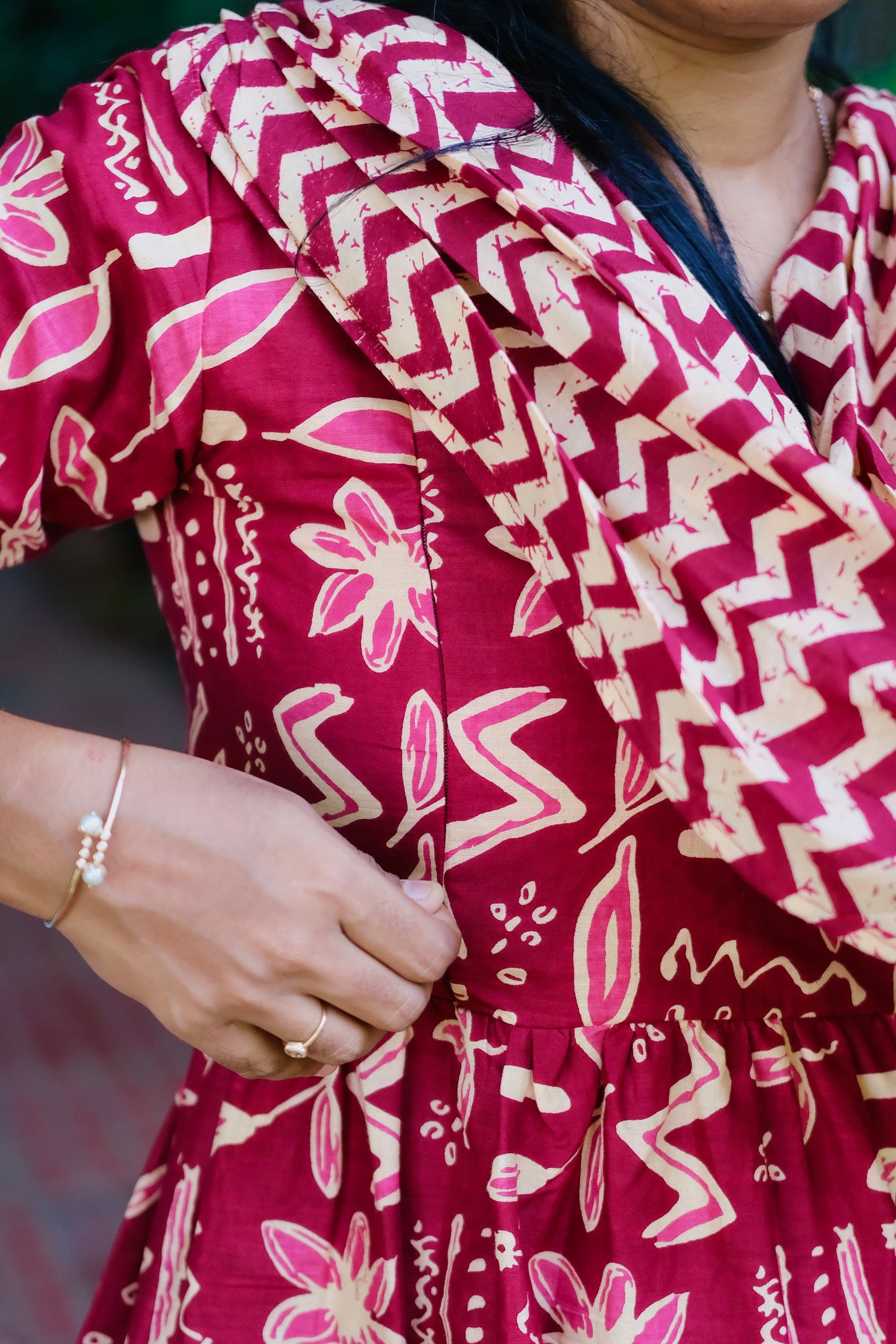 Close-up of the side zipper on the feeding friendly nighty showing the red batik print.
