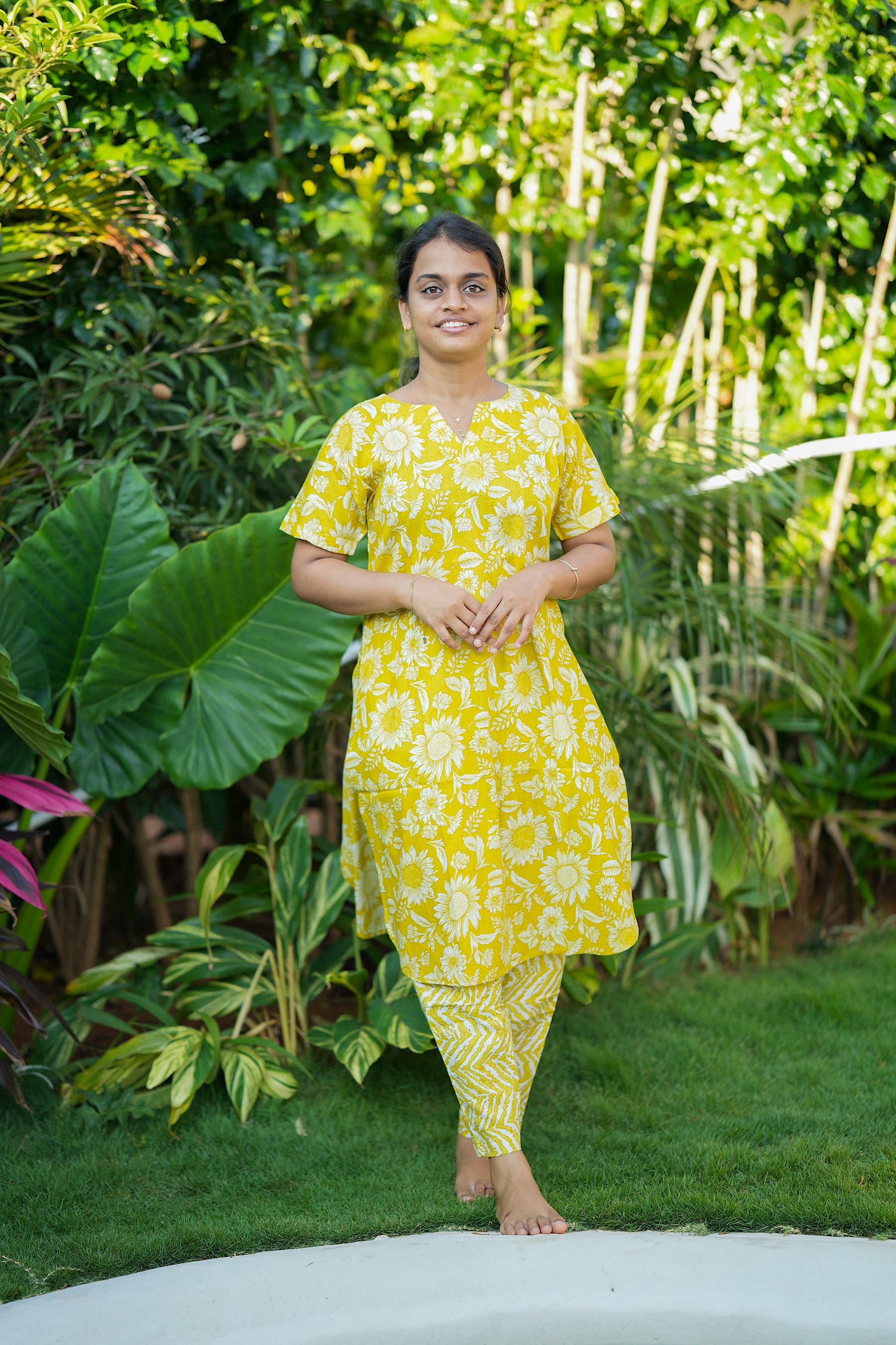 Yellow floral cotton night suit for women featuring a long top with sunflower prints and matching chevron pants.