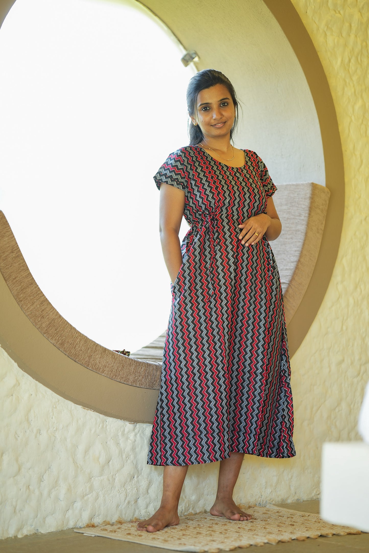 Comfortable cotton nighty with pockets in a black and red chevron print showing side pocket detail.