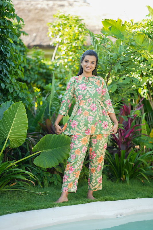Model showcasing the relaxed fit of the green floral printed cotton loungewear set with gathering details.