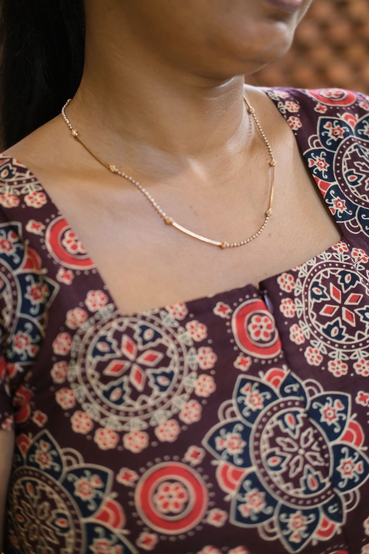 Close up of square neck and medallion print on maroon cotton nighty