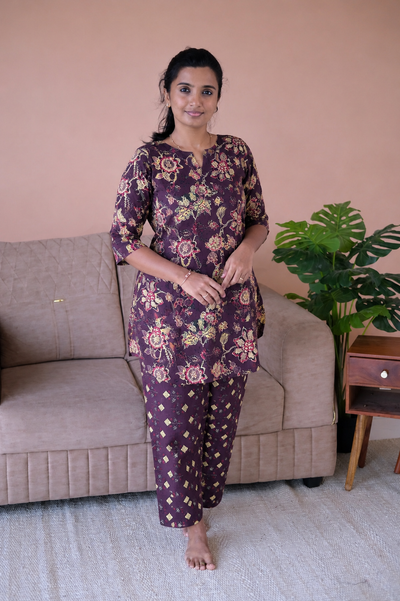 Plum purple cotton night suit for women featuring a floral printed top with 3/4 sleeves and matching geometric print pants