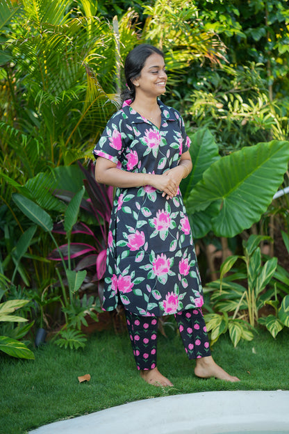 Ladies cotton night suit in black with vibrant pink floral print, side view.
