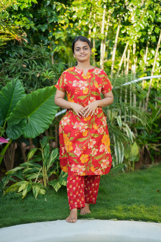 Red printed cotton night suit for women featuring a longline floral top and matching straight pants.