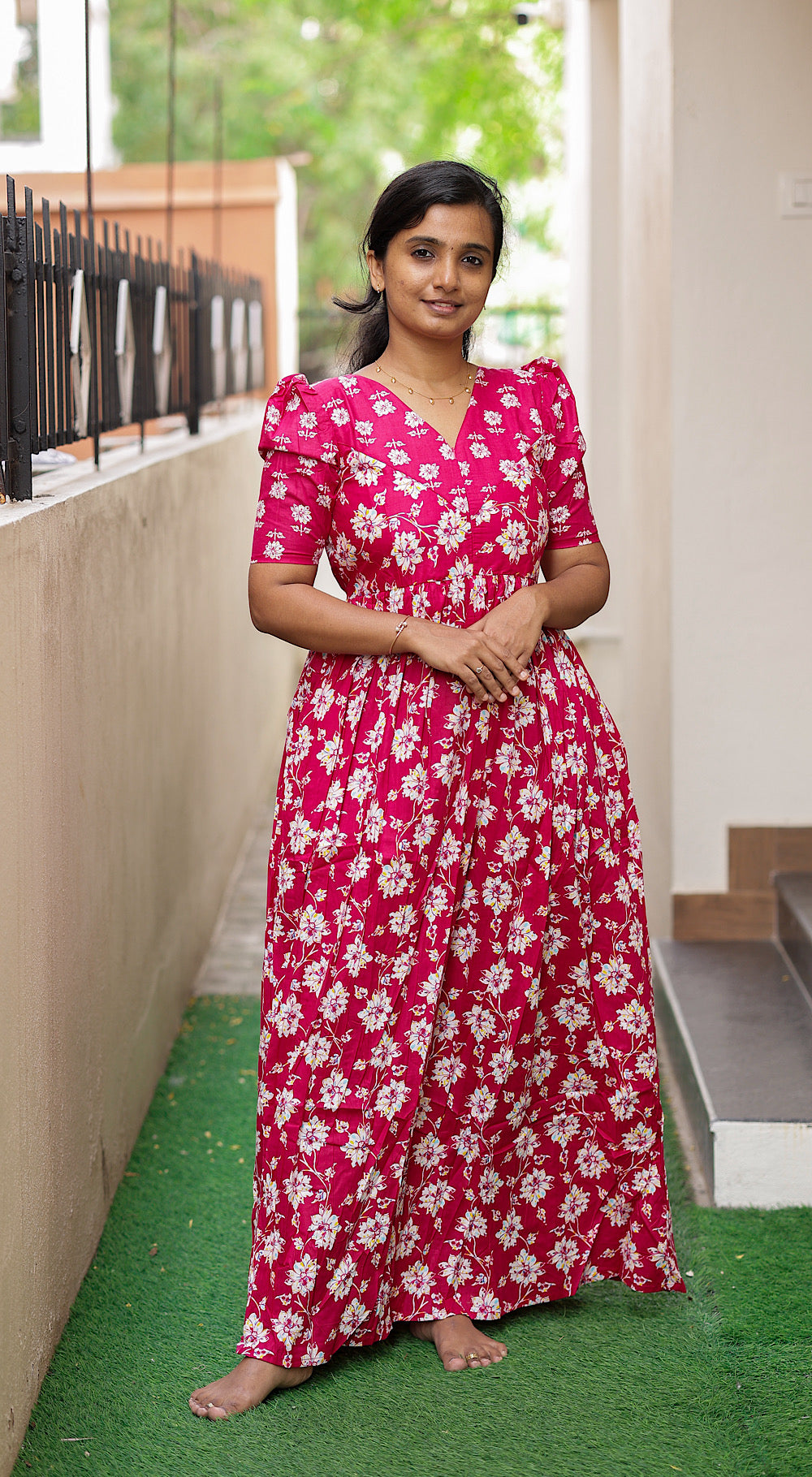 Full-length front view of the Yamini pink cotton maxi nighty featuring a vibrant floral print and elegant puff sleeves.