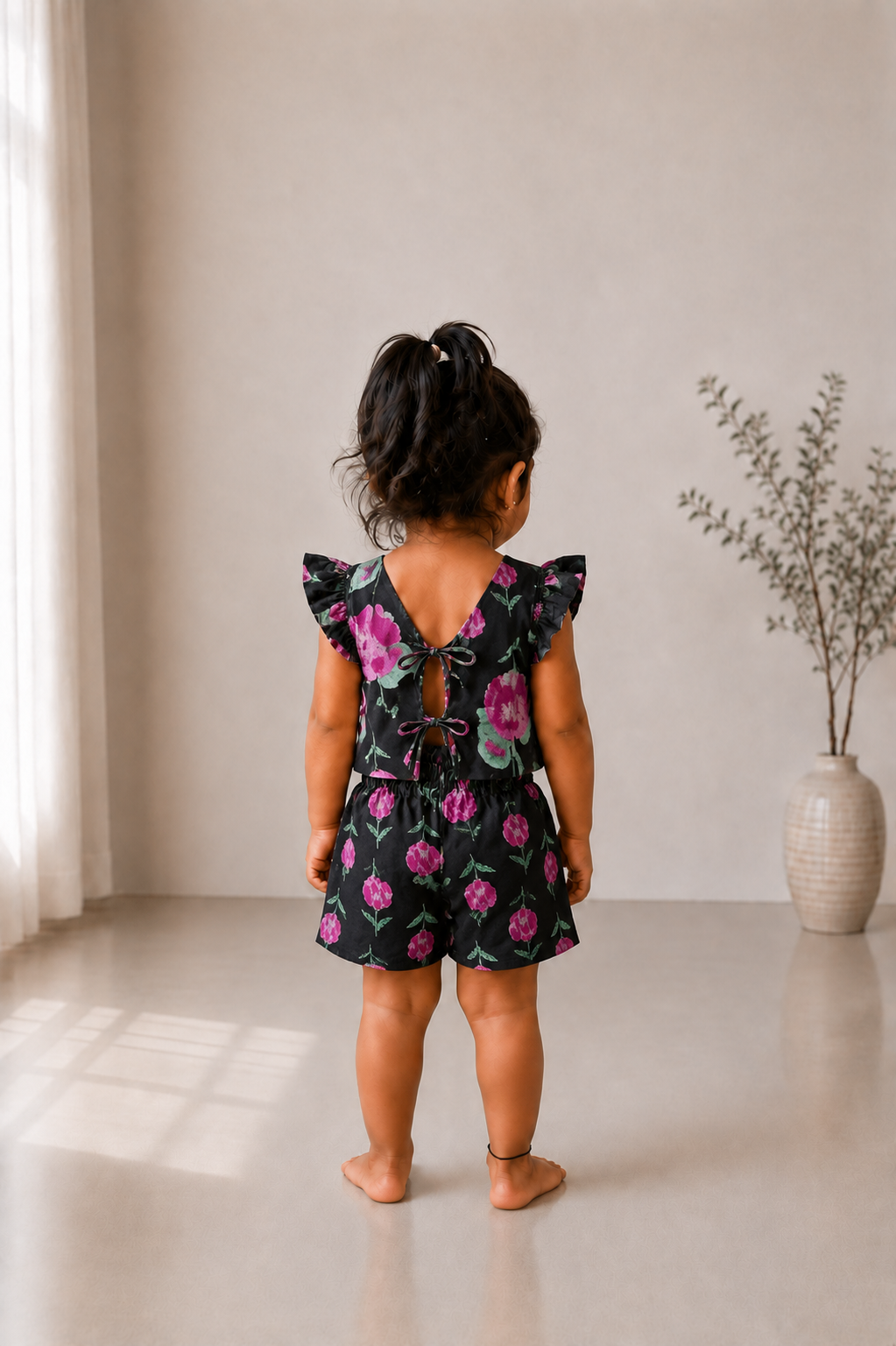Back view of black floral kids co-ord set showing double tie-up back detail