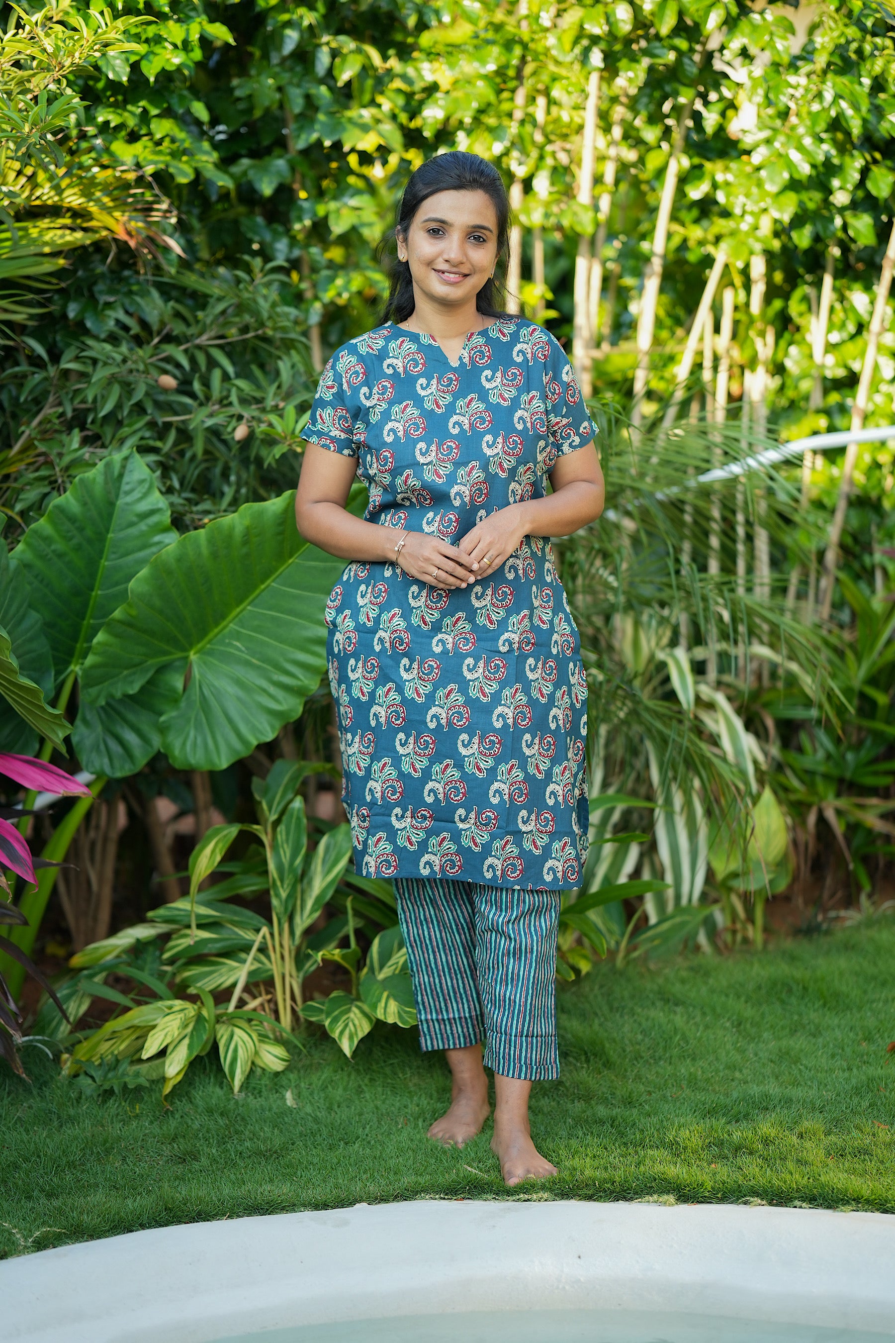 Krithi teal green printed cotton night suit for women featuring a longline tunic top and striped straight pants.