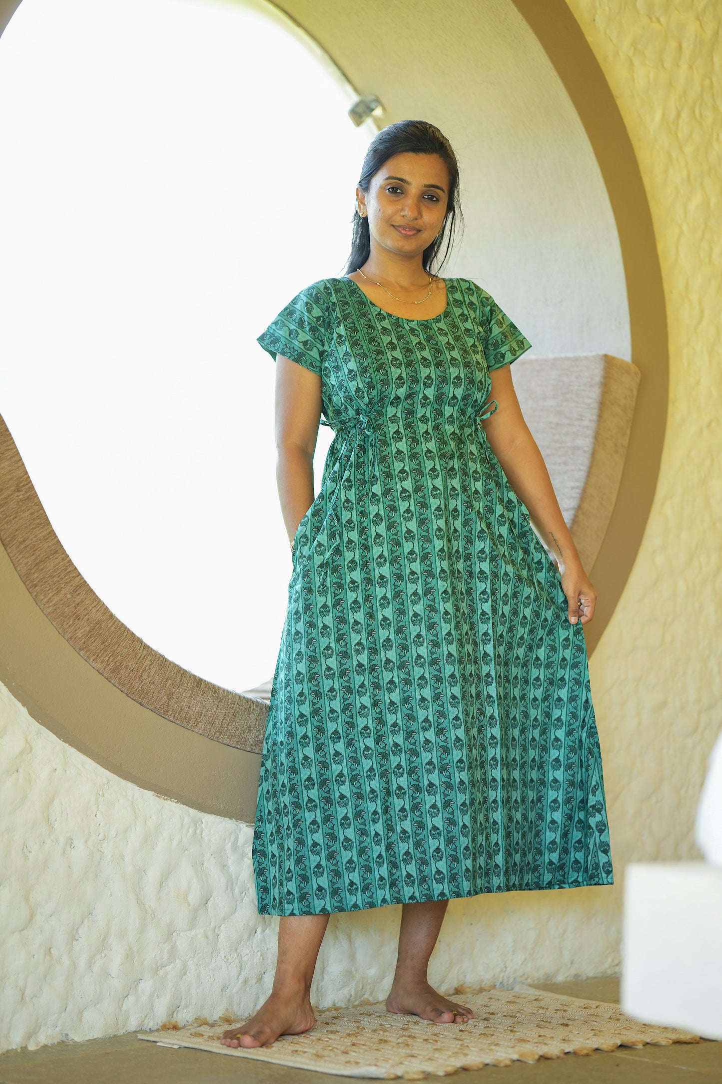 A-line ladies cotton nighty in green with vertical prints and functional side pockets.
