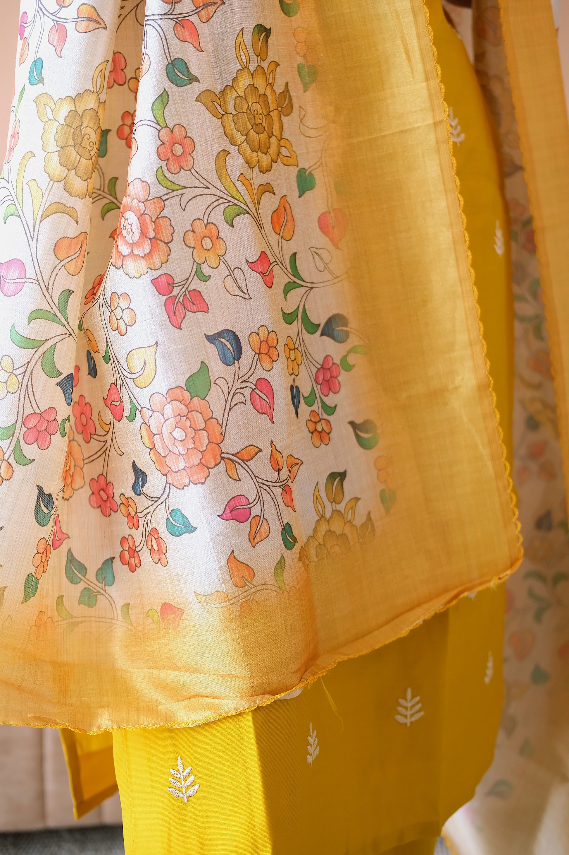 Close-up of the colorful floral print and golden border on the dupatta of the yellow kurti set.