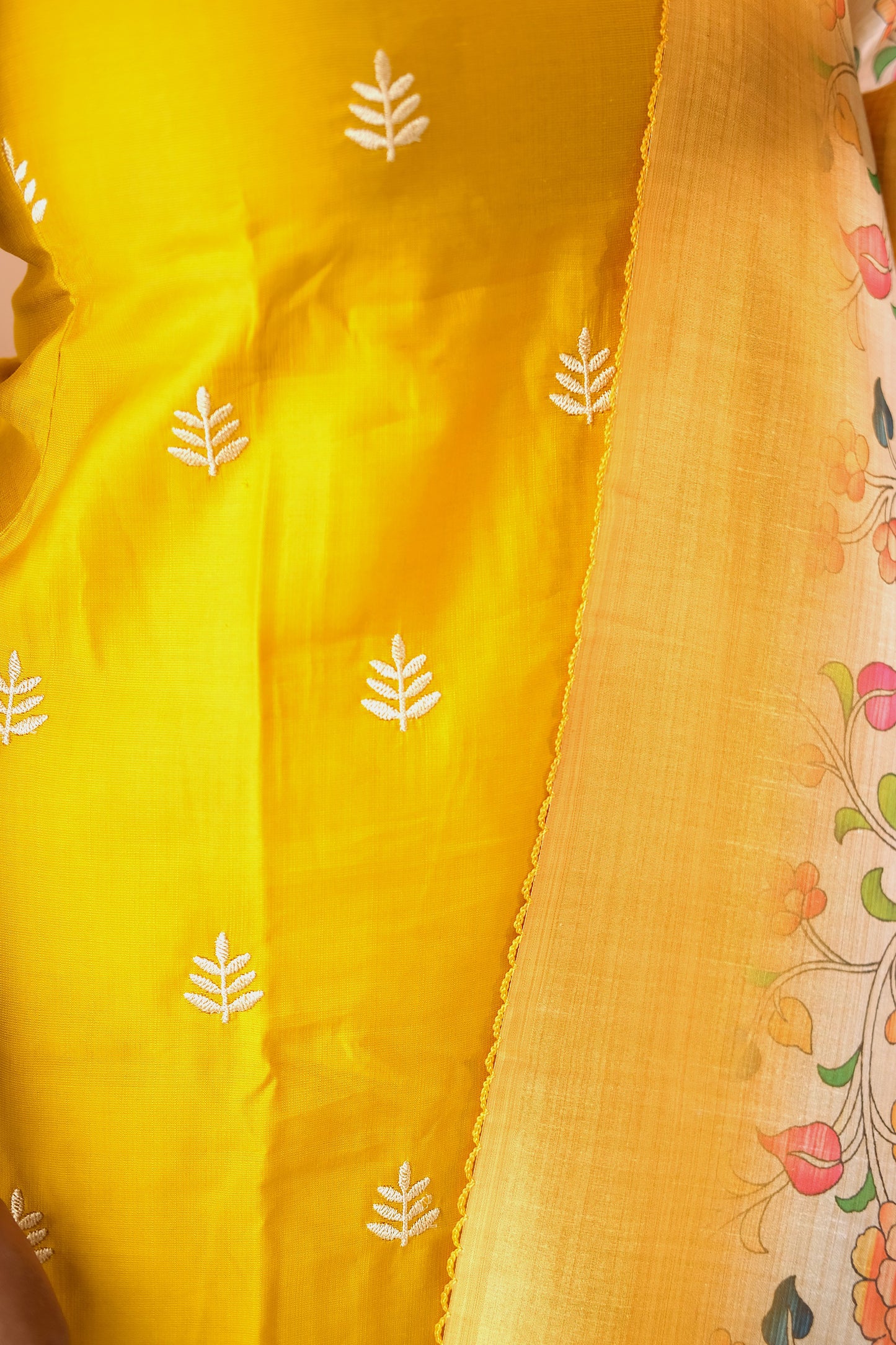 Detailed view of the white leaf embroidery on the yellow silk-blend fabric of the feeding friendly kurta set.