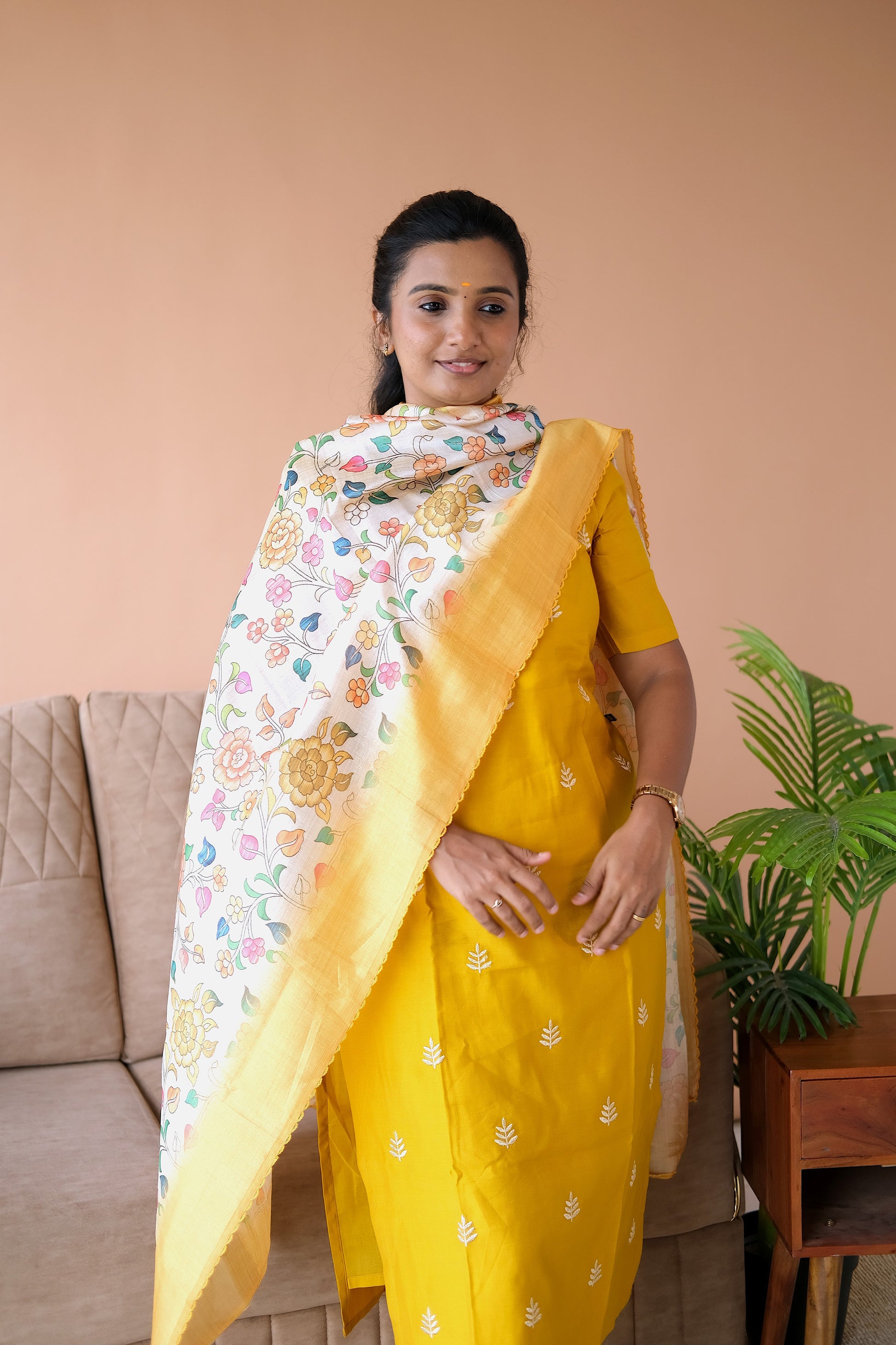 Close-up of the scallop neck design and elbow sleeves on the yellow silk kurti set with dupatta.