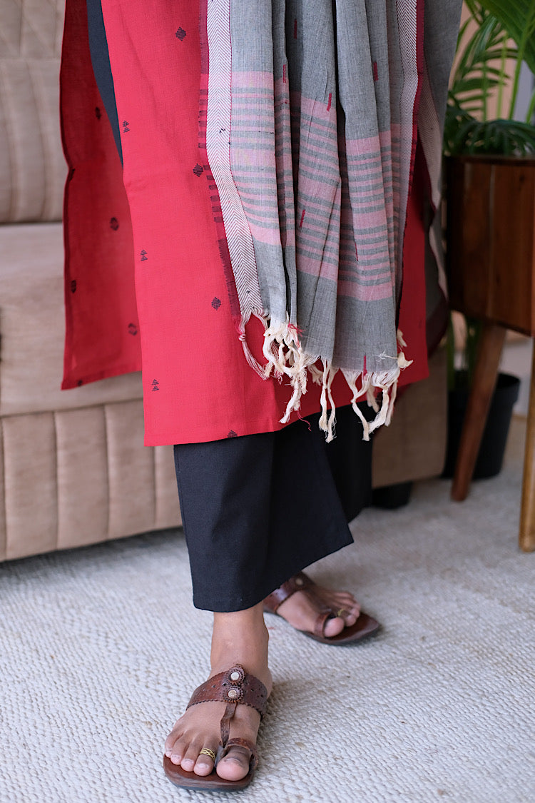 Close-up of Manasa cotton salwar set showing hemline, black pants, and tasseled grey dupatta details