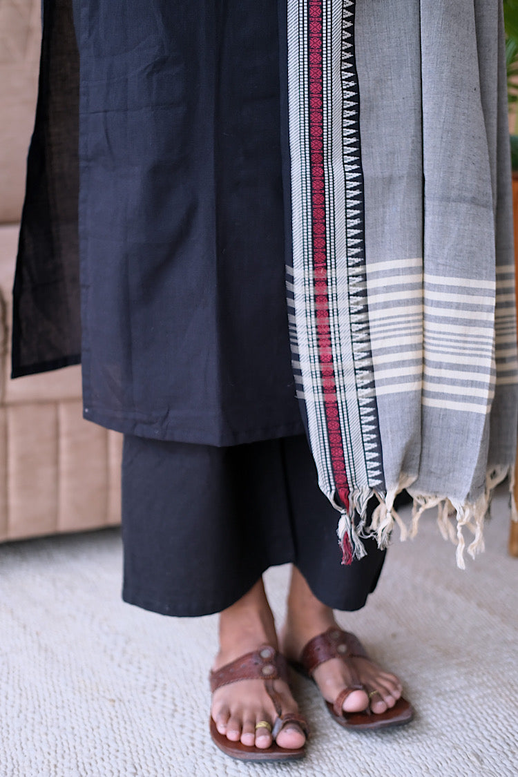 Close-up of the grey handloom dupatta border with tassels and the hem of the navy blue cotton kurti set