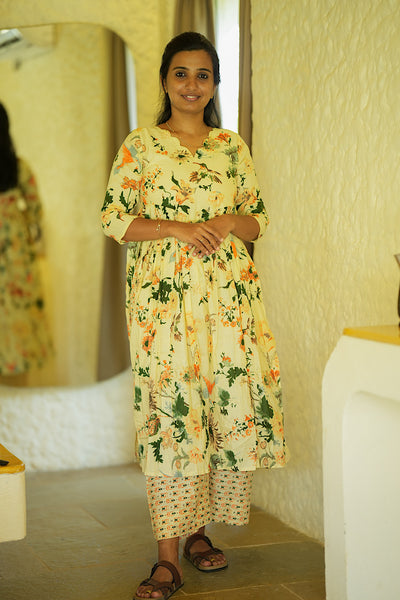 Yellow cotton kurti set with pants featuring an inverted Alia cut and floral prints