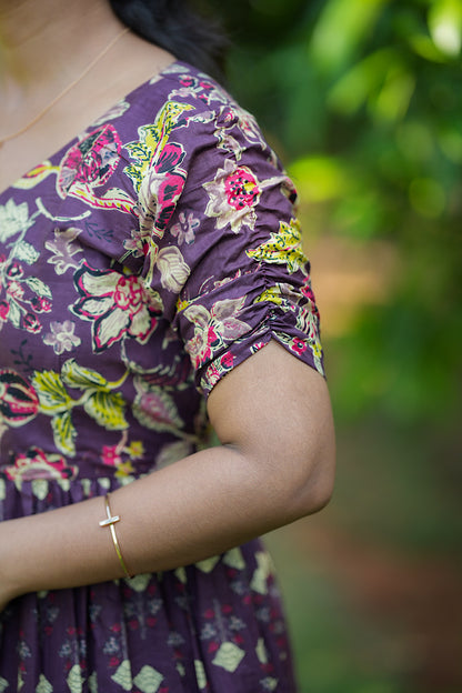 Close-up of the gathered short sleeve detail on the violet printed dress