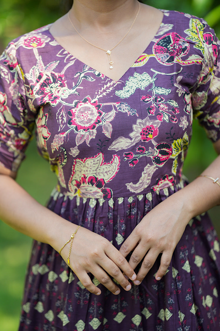 Close-up of the V-neckline and floral block print on the violet cotton maxi dress