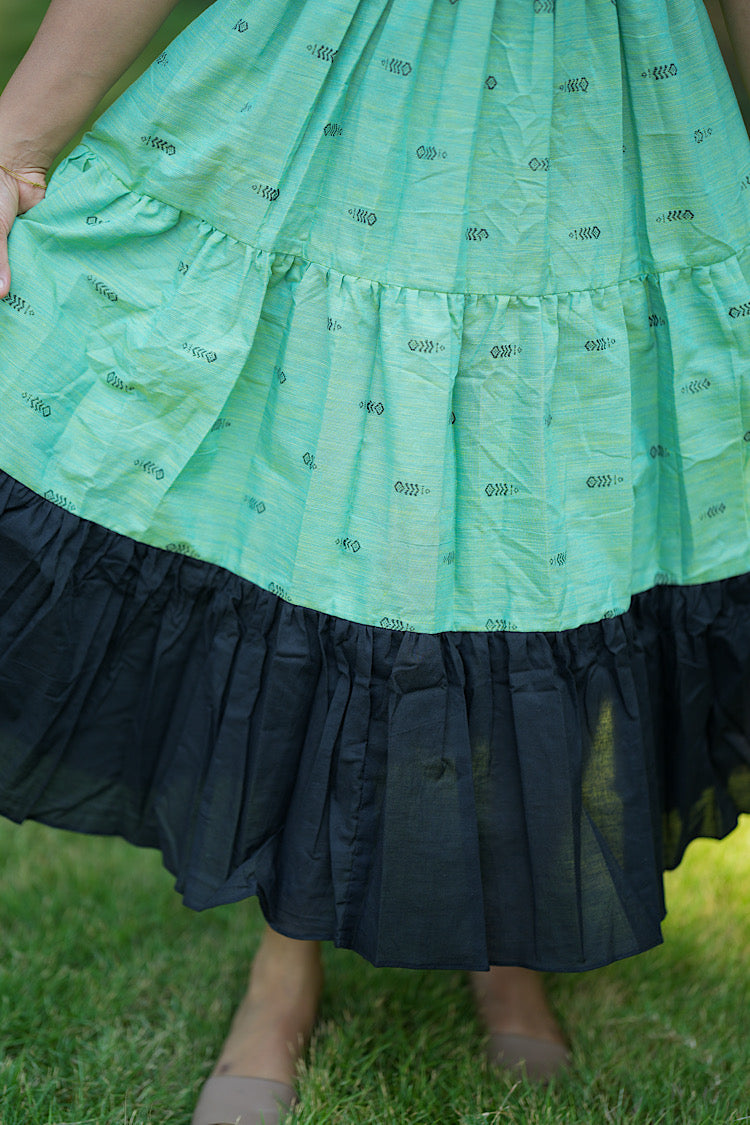 Close-up of the tiered skirt showing the contrast solid black gathered hem