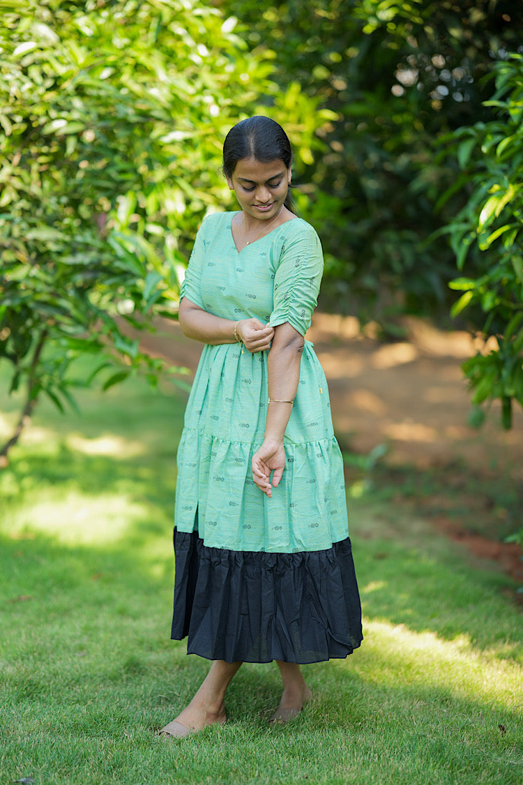 Side view of the green cotton maxi dress showing the elbow-length gathered sleeves