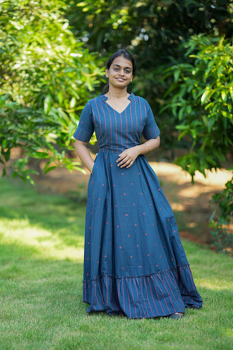 Floor-length blue cotton maxi dress for women with side pockets and elbow-length sleeves.