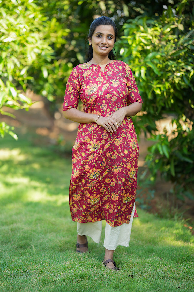 Deep pink Kalamkari print cotton kurti with elbow sleeves paired with off-white trousers