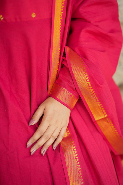 Close-up of the sleeve cuff featuring the traditional golden zari border on the red cotton fabric.