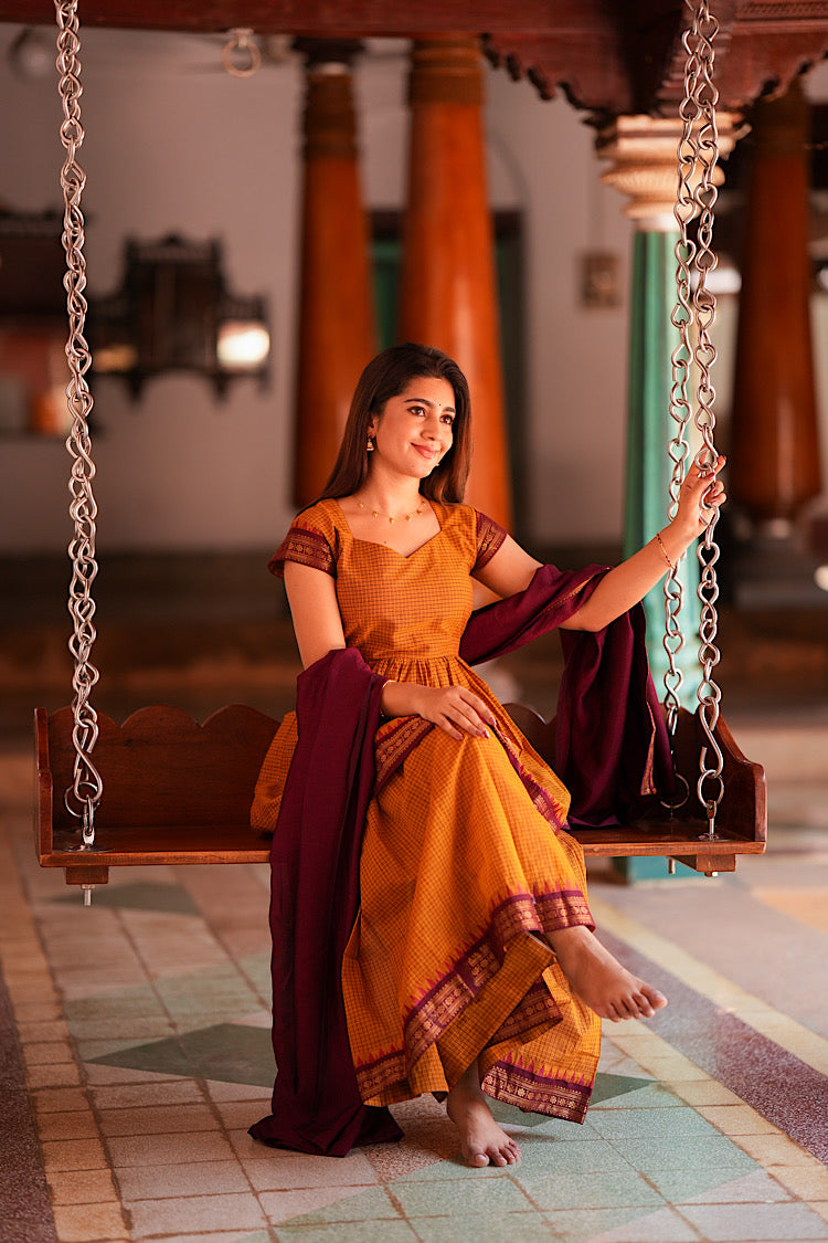 Model sitting on swing wearing ethnic chettinad cotton sharara