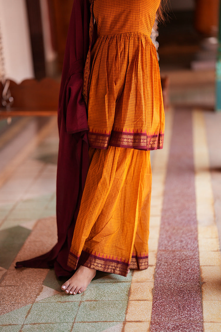 Side profile of mustard sharara suit with contrasting dupatta