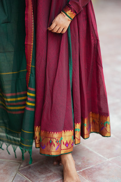 Close-up of the flared hemline of the maroon cotton anarkali with woven peacock motifs.