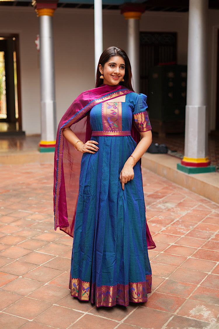 Peacock blue ethnic gown with a magenta dupatta draped over the back.