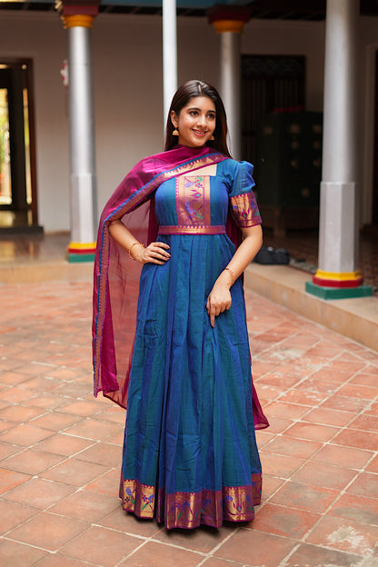 Peacock blue ethnic gown with a magenta dupatta draped over the back.