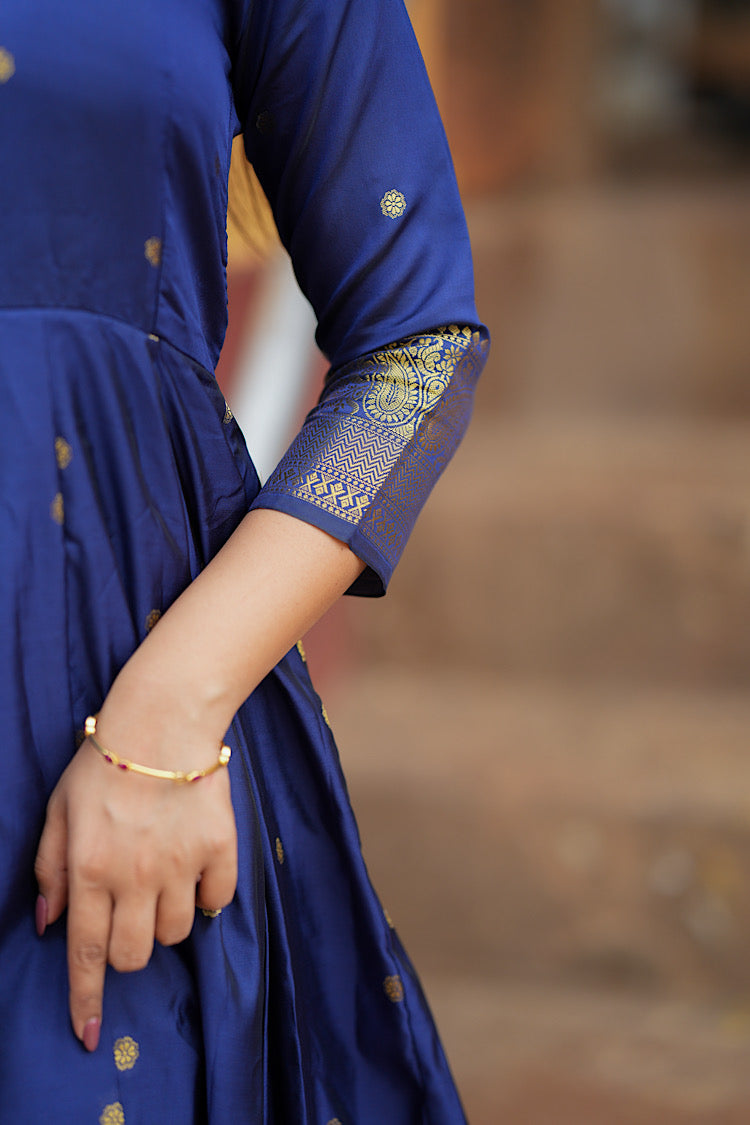 Detailed close-up of the gold zari border on the 3/4th sleeve of the blue silk anarkali