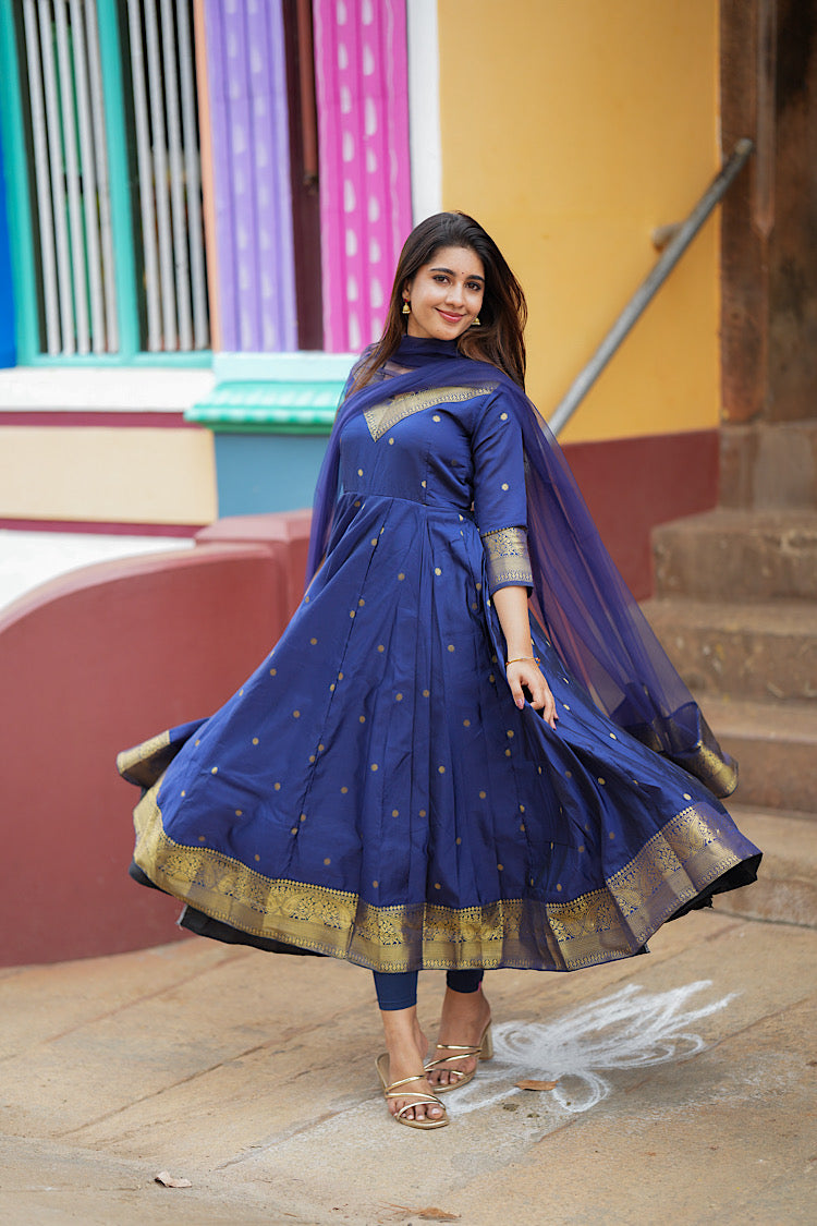Twirling shot showing the wide flare of the royal blue panelled anarkali suit