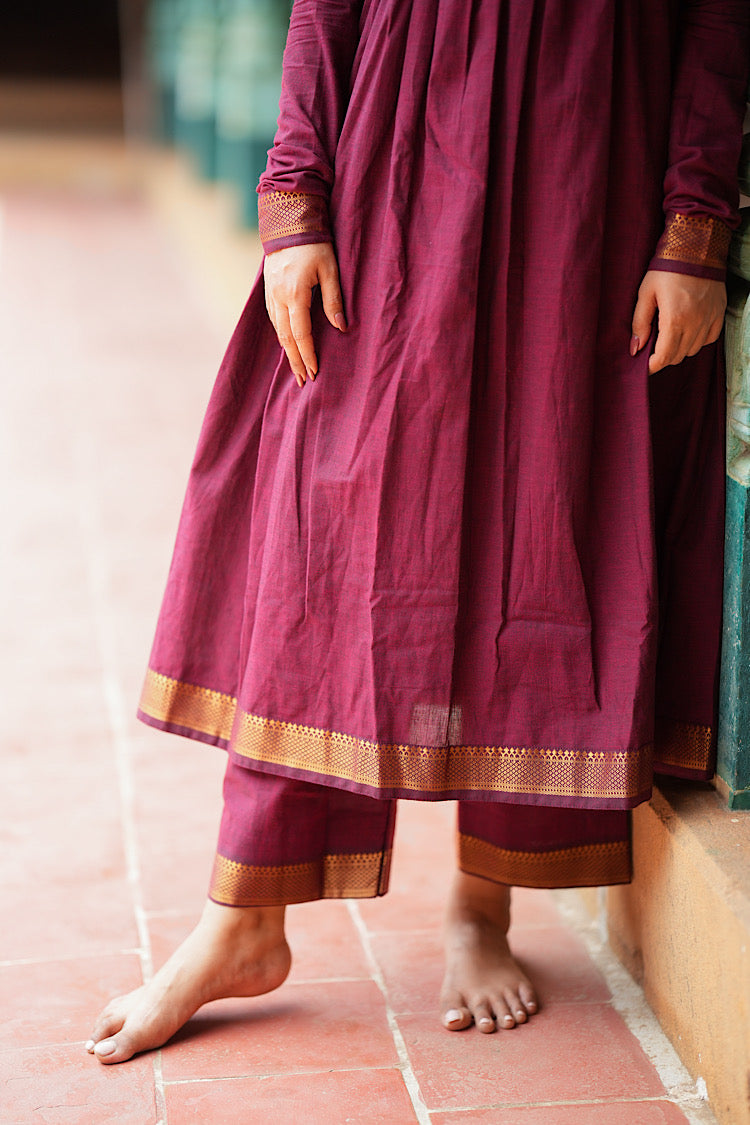 Close-up of the woven gold zari border on the hem of the maroon palazzo pants