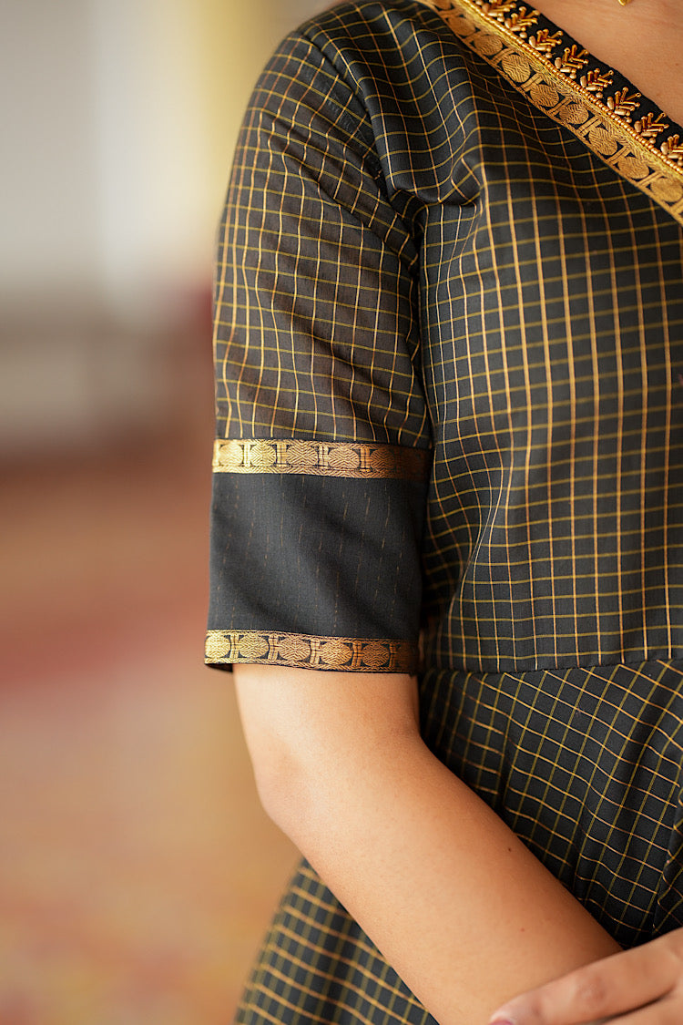 Close-up of the elbow-length sleeve with solid black cuff and gold border