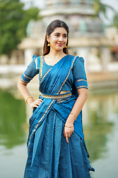 Elegant pose showing the full flare of the peacock blue pleated skirt