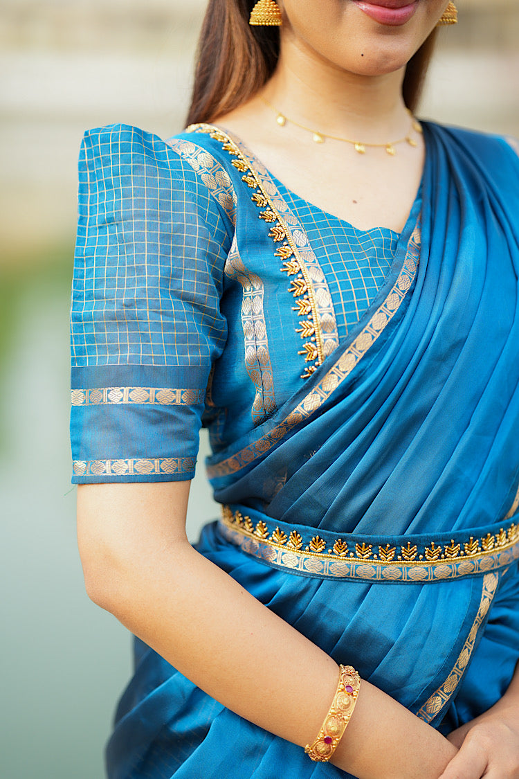 Close-up of the puff sleeves and gold zari check pattern on the peacock blue crop top