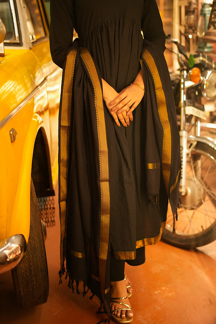 Lower half of the black anarkali suit set showing the flared hemline and matching black pants.