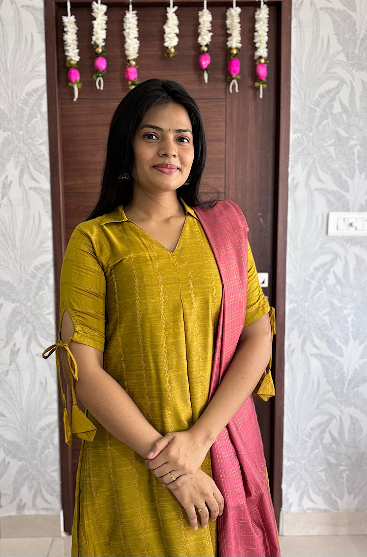 Close-up of mustard yellow collared kurta with tied keyhole sleeves and mauve pink dupatta