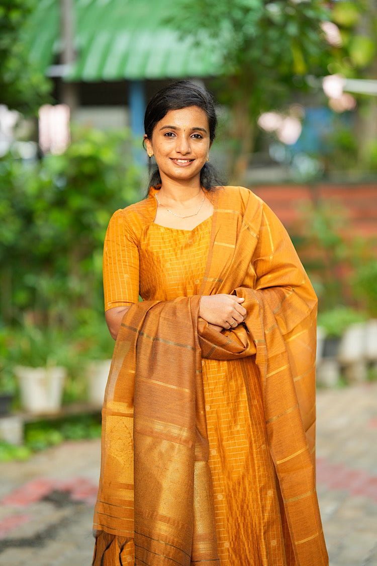 Front portrait of mustard yellow raw silk A-line kurta set with dupatta