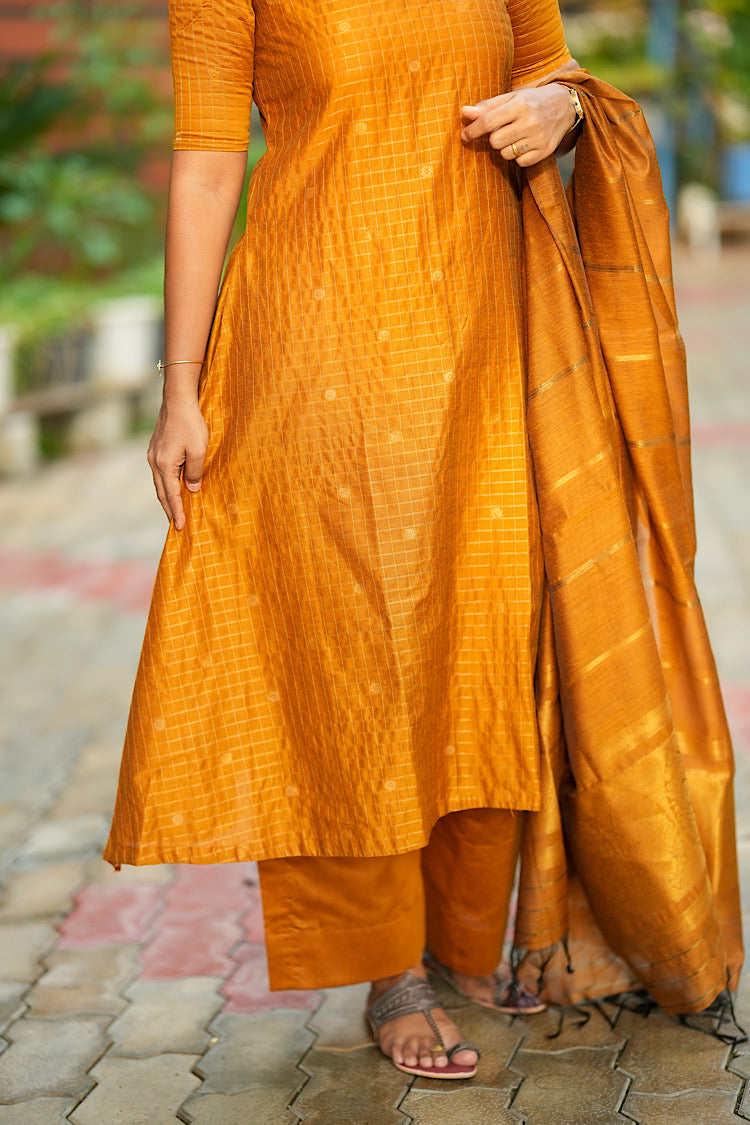 Lower hem flare of yellow raw silk kurti set paired with straight pants