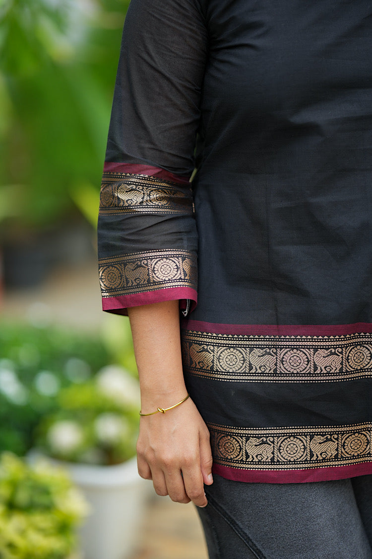 Close-up of woven gold zari motif border on black Chettinad cotton sleeve