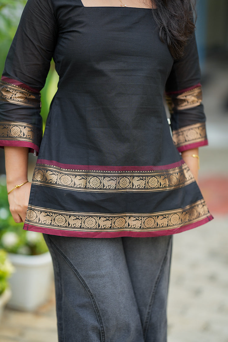 Detailed view of hemline border and side pocket on black Chettinad cotton top